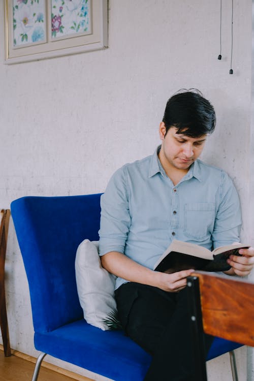 Man Sitting and Reading a Book 