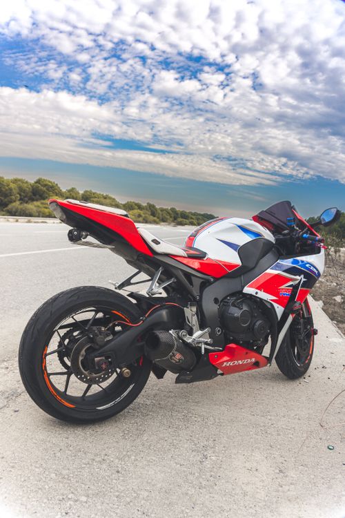 Free Honda motorcycle parked on a scenic road in Mersin, Türkiye, under a bright sky. Stock Photo