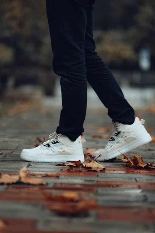 Free Close-Up Shot of a Person in Black Pants Wearing White Rubber Shoes Stock Photo