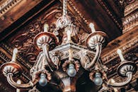 复古华丽的枝形吊灯特写，展现了其复杂的设计与金色色调