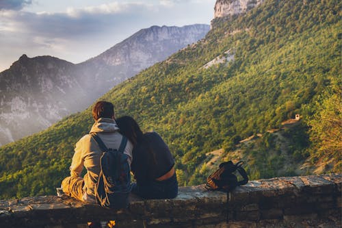 Free Couples Sitting in While Facing Mountain Stock Photo