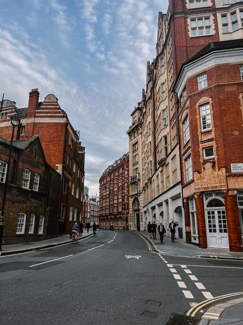 Free Beautiful cityscape featuring historic buildings on a vibrant urban street with a blue sky. Stock Photo