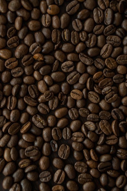 Free Close-up of roasted coffee beans showcasing their rich brown texture and detail. Stock Photo