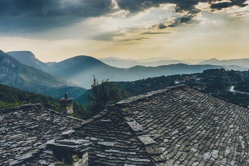 Free Breathtaking view of mountains and slate roof under a dramatic sky at sunset. Stock Photo