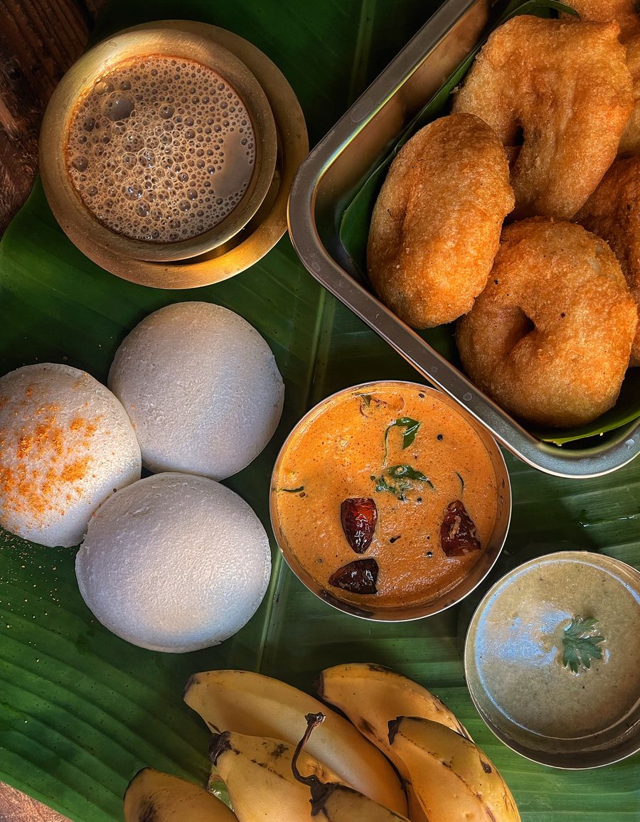 South Indian breakfast with idli, vada, chutney and coffee on banana leaf