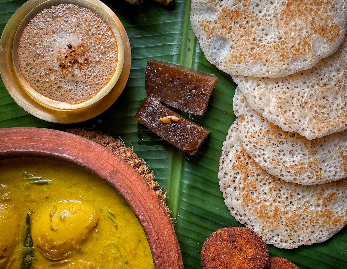 Dosa, curry, bananas and coffee served on a banana leaf