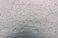 金属背景上水滴形成的图案细节，纹理与清晰度突出