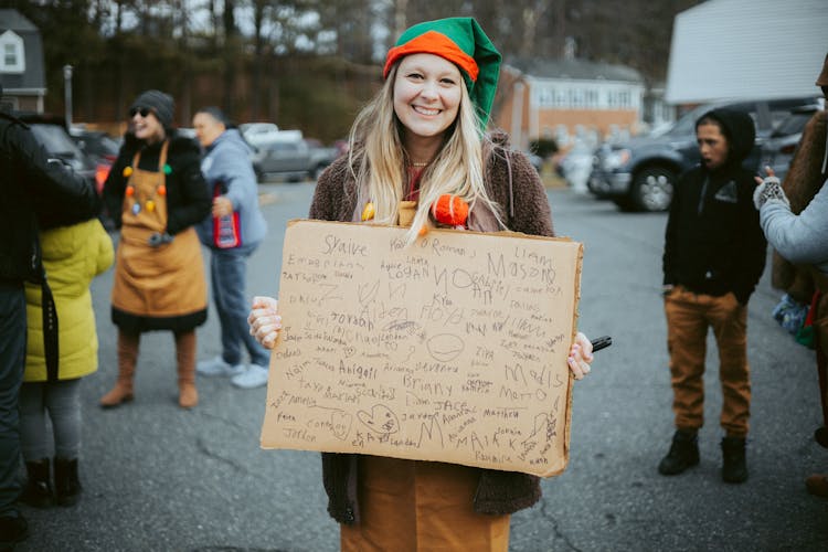 Woman In A Christmas Costume Holding A Board With Signatures 