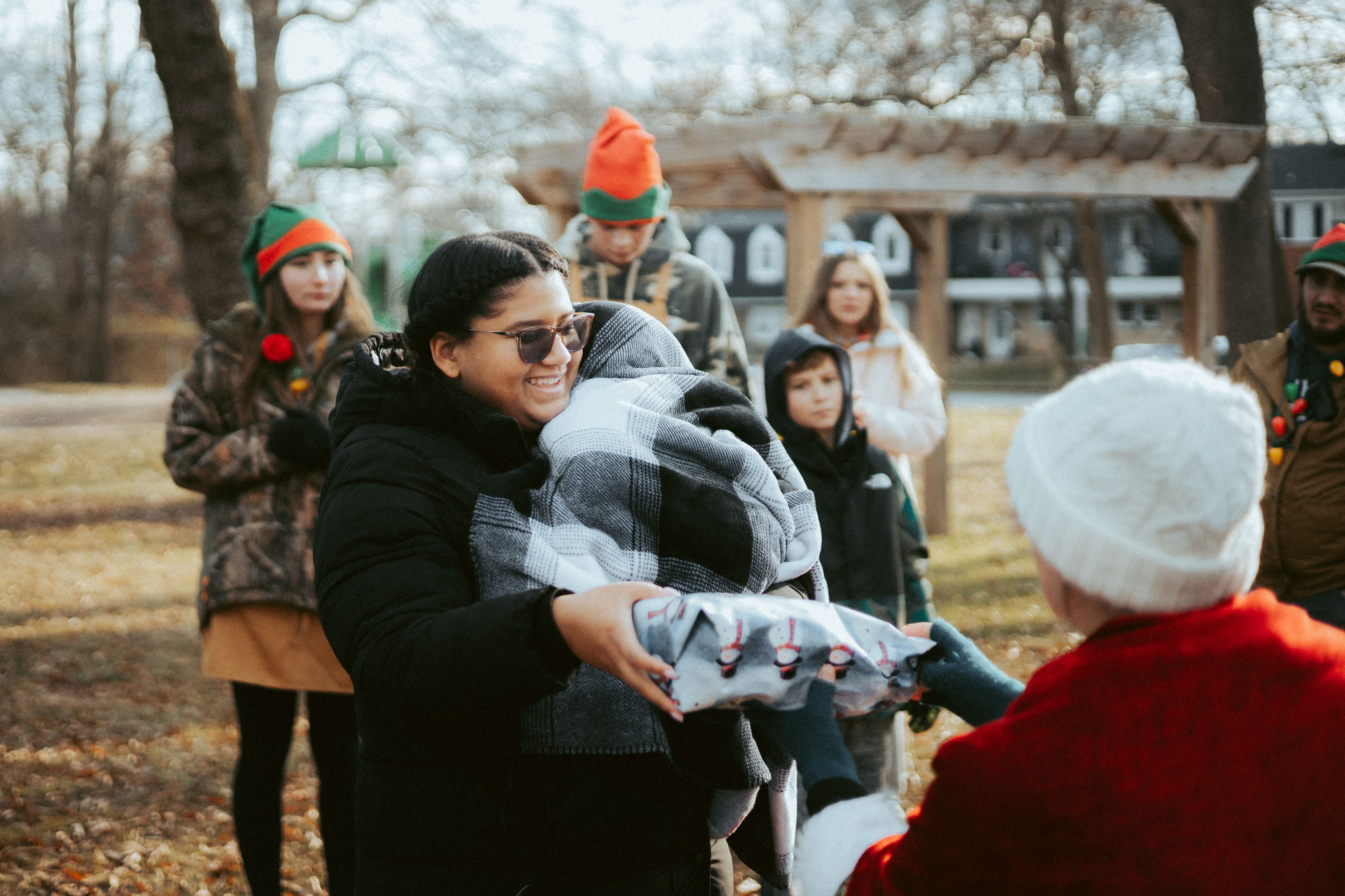 People in Christmas Costumes Giving Away Presents on the City Street