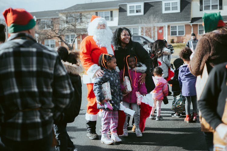 Children Posing With Santa Claus On A Christmas Event In City 