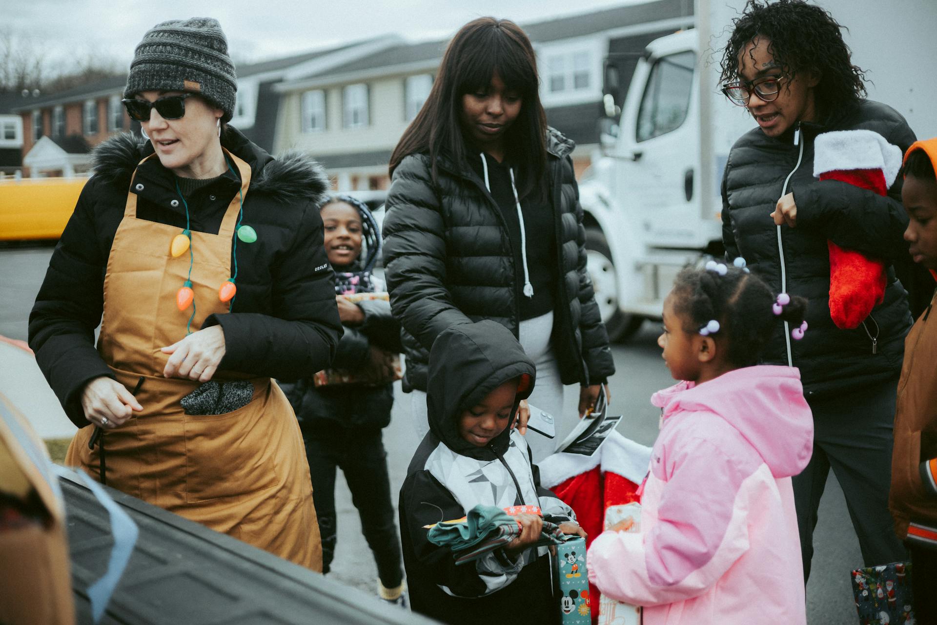 Volunteer Giving Presents to Children on a Christmas Event in City