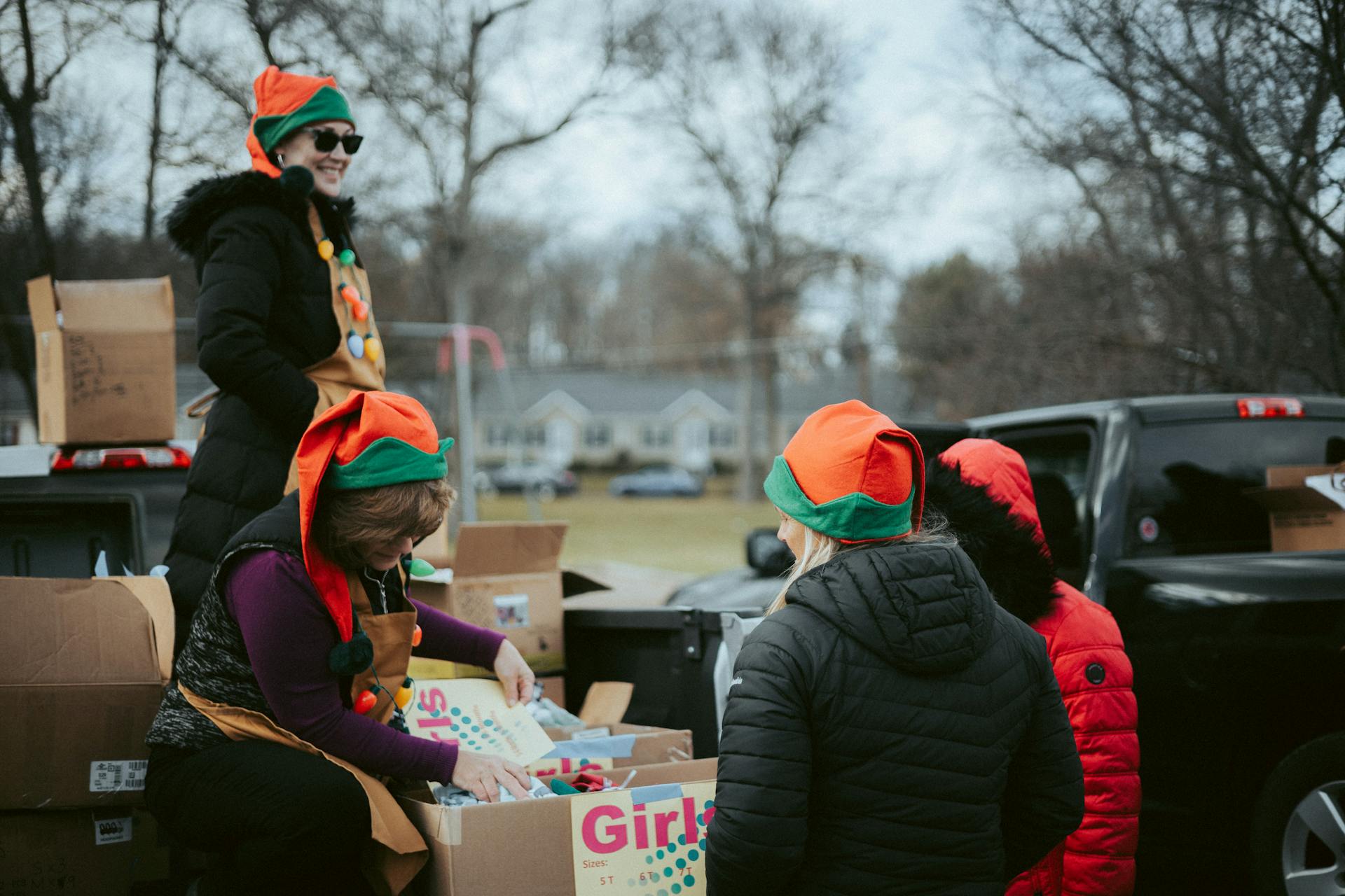 People in Christmas Costumes Giving Presents on a Christmas Event in City