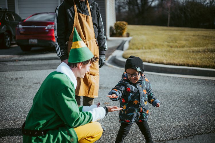 A Child And A Man Dressed As A Christmas Elf 