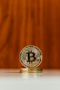 Close-up image of a Bitcoin coin against a wooden backdrop, symbolizing cryptocurrency.