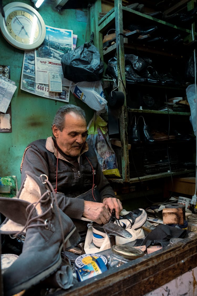 Shoemaker Repairing Shoes In His Workshop 