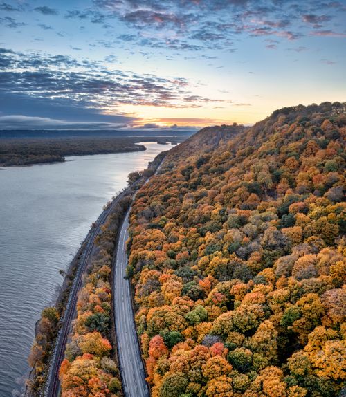 Free A stunning autumn landscape showcasing colorful trees along the Mississippi River at sunset. Stock Photo