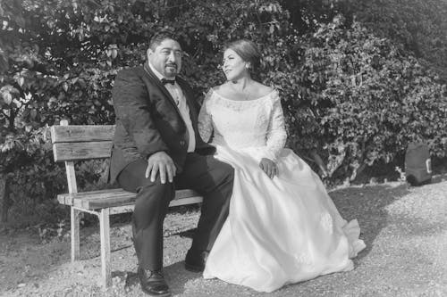 Newlyweds Sitting on Bench in Black and White