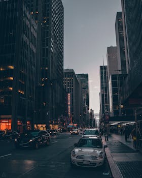 黄昏时分，纽约市繁忙的街道两旁，摩天大楼林立，捕捉着城市生活的气息