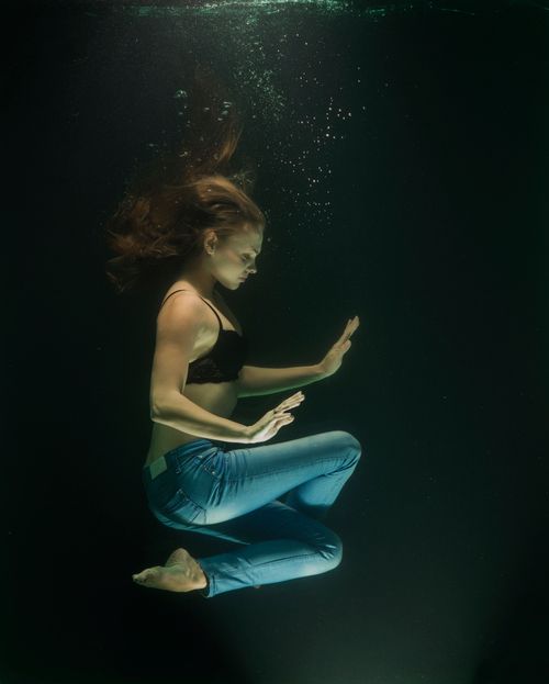 Free A serene underwater portrait of a woman in motion, showcasing grace and elegance. Stock Photo