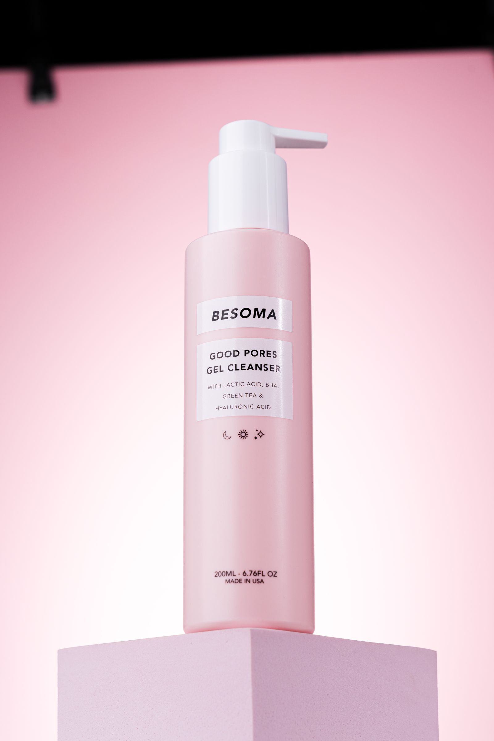 Pink gel cleanser bottle with pump displayed without people