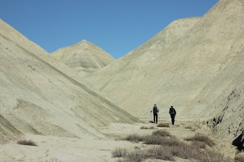Photo of Two People Walking in the Desert