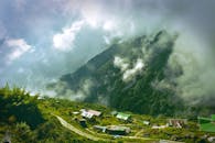 云雾缭绕的山脉与郁郁葱葱的绿意之间，坐落着一座古色古香的村庄，非常适合旅行爱好者