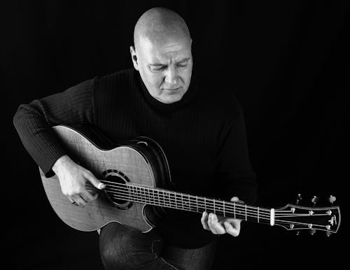 Man in Sweatshirt Playing a Guitar