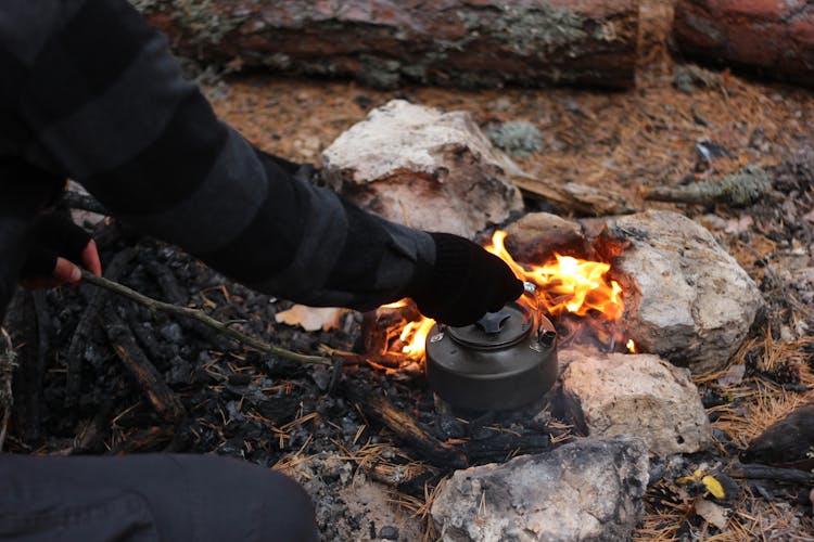 Hiker Cooking Meal Over A Campfire Outdoors 