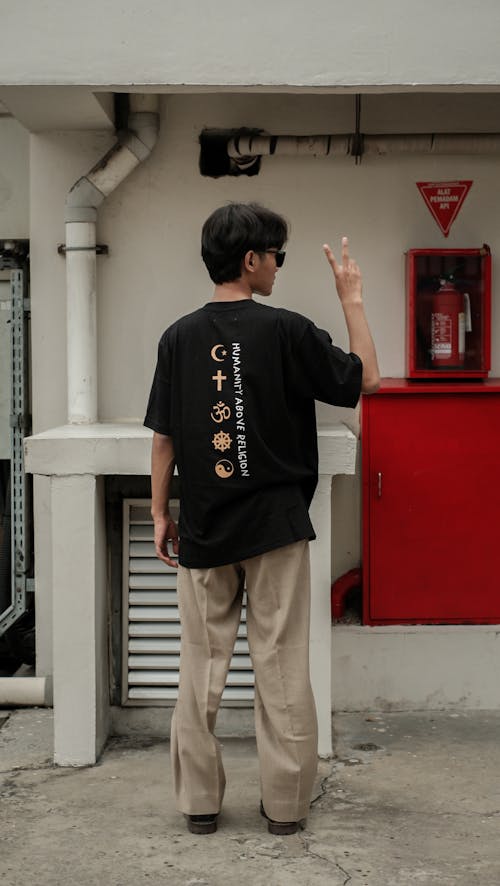 Back View of a Man in a Black Shirt Doing a V Sign