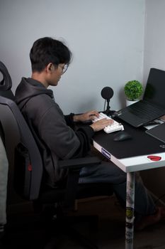 A man typing on a laptop in a contemporary office with minimalist decor.