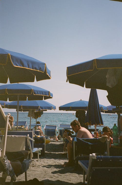 People on Beach under Umbrellas on Summer Day