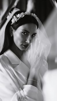 A sophisticated black and white portrait of a bride in a wedding dress with a delicate veil.