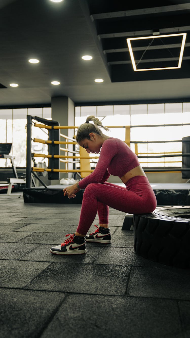 A Woman Sitting In A Gym