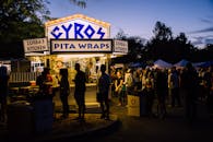 晚上，美食节摊位前聚集了人群，供应着陀螺和皮塔饼卷