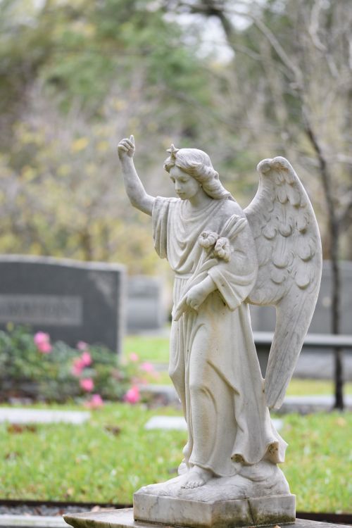 Free Elegant angel sculpture at a cemetery, exuding tranquility and grace. Stock Photo