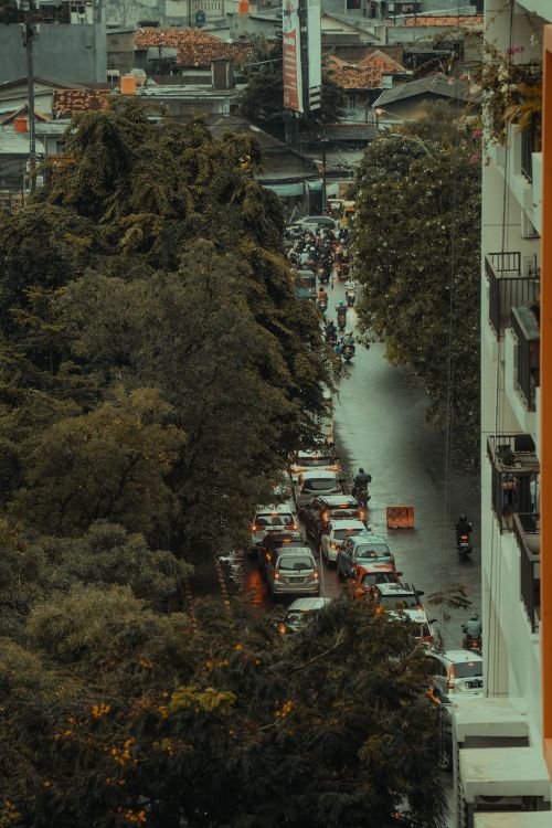 Free Aerial view of Jakarta street in the rain, showing urban traffic congestion and cityscape. Stock Photo