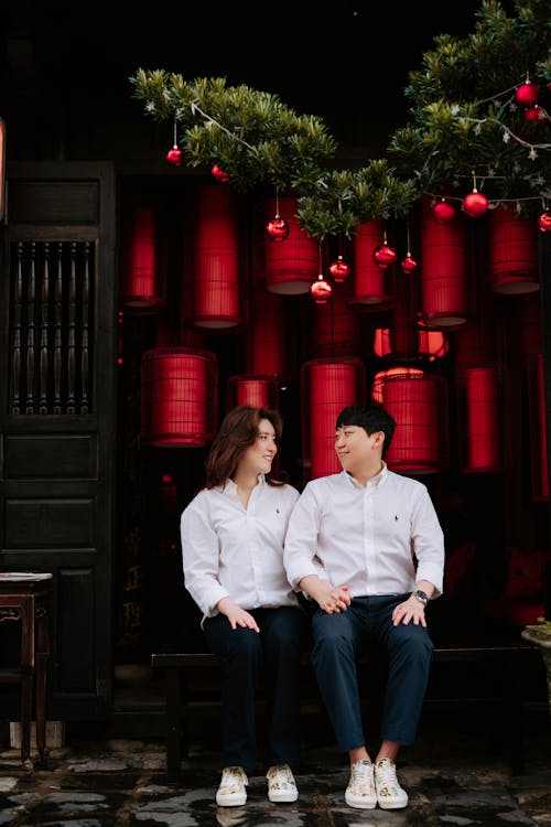 A Couple Sitting Under a Christmas Decoration