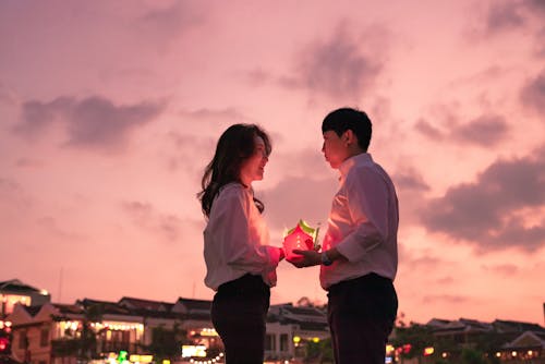 Photo of a Man and a Woman Holding a Lantern