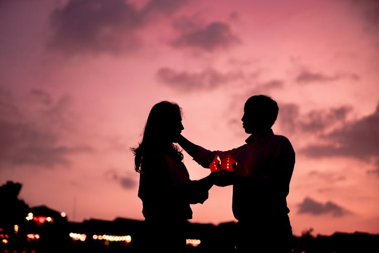 Silhouettes Of A Man And A Woman With A Lantern