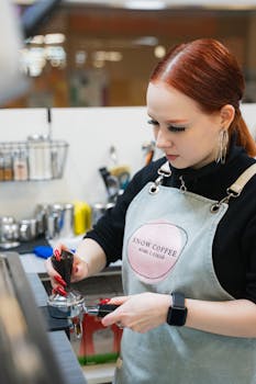 Barista in a coffee shop preparing espresso with professional equipment.