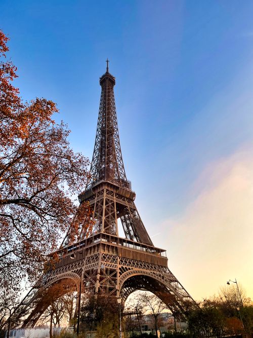 Free Stunning view of the Eiffel Tower in Paris during sunset with autumn trees. Stock Photo