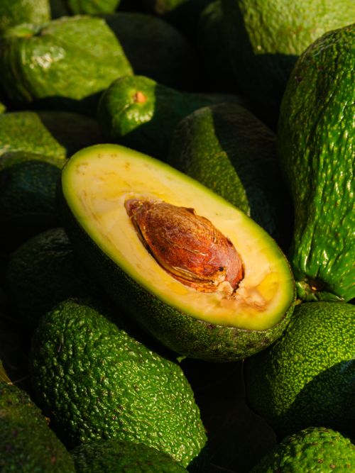 Free Close-up of a ripe avocado halved to reveal its seed and green flesh, emphasizing freshness and health. Stock Photo