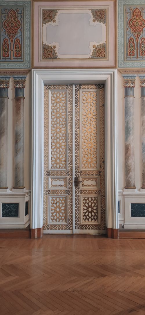 Free Elegant ornate wooden door with intricate carvings set in a decorated wall. Stock Photo