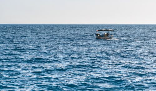 Free A small boat cruising through the blue Mediterranean sea near Eastern Hawaria, Tunisia. Stock Photo