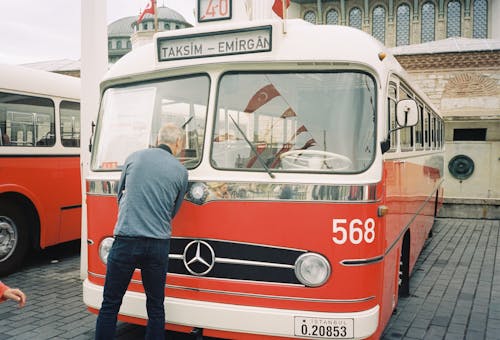 Man Standing in front of a Bus 