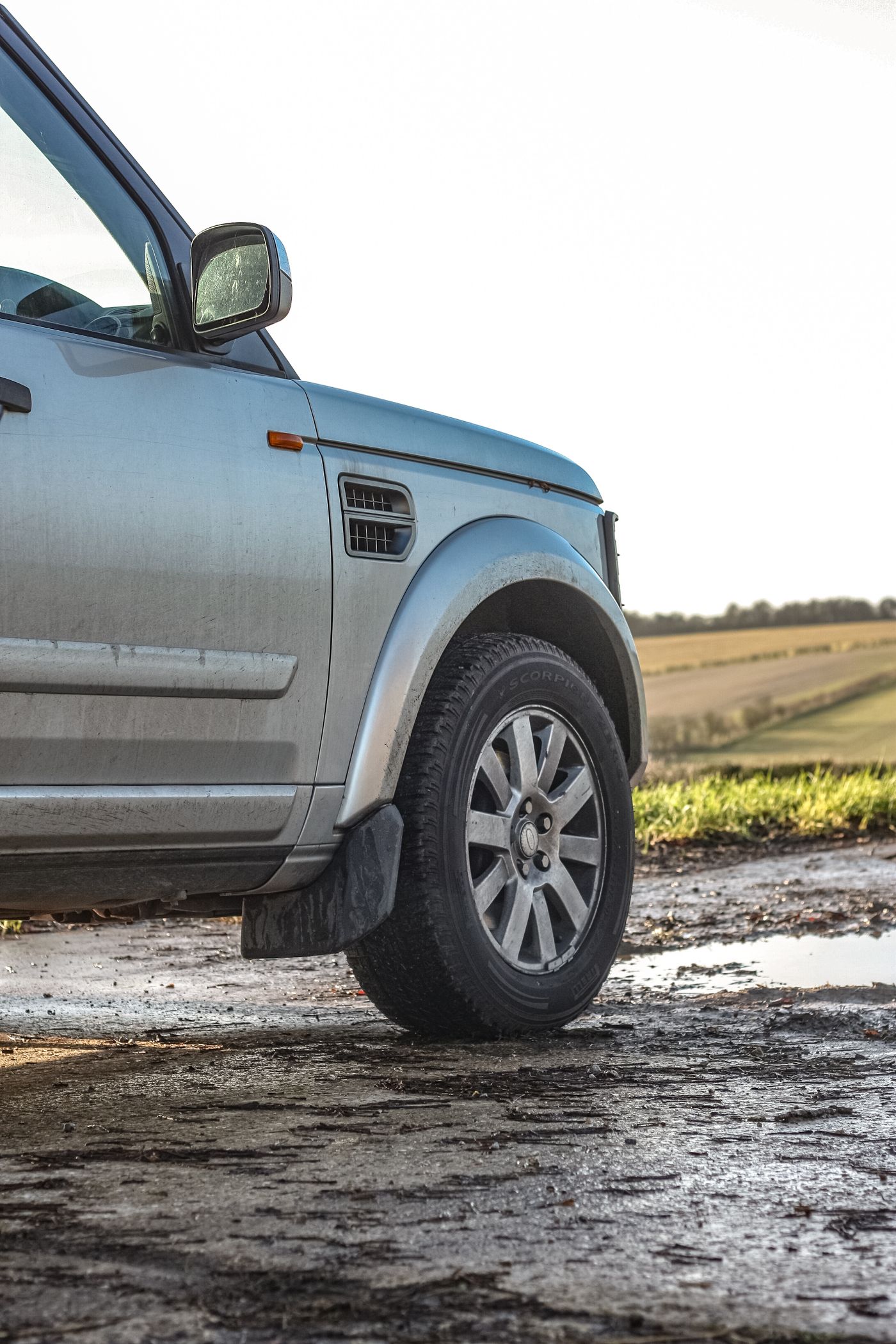 Vehicle and tire on wet muddy ground after rain
