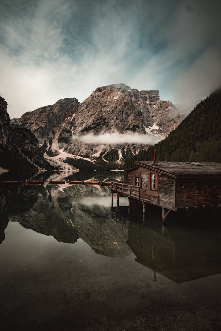 Wooden House In Water In Mountains Landscape