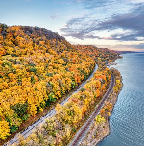 Free Stunning aerial view of autumn trees and a winding road by Lake Pepin in Reads Landing, MN. Stock Photo