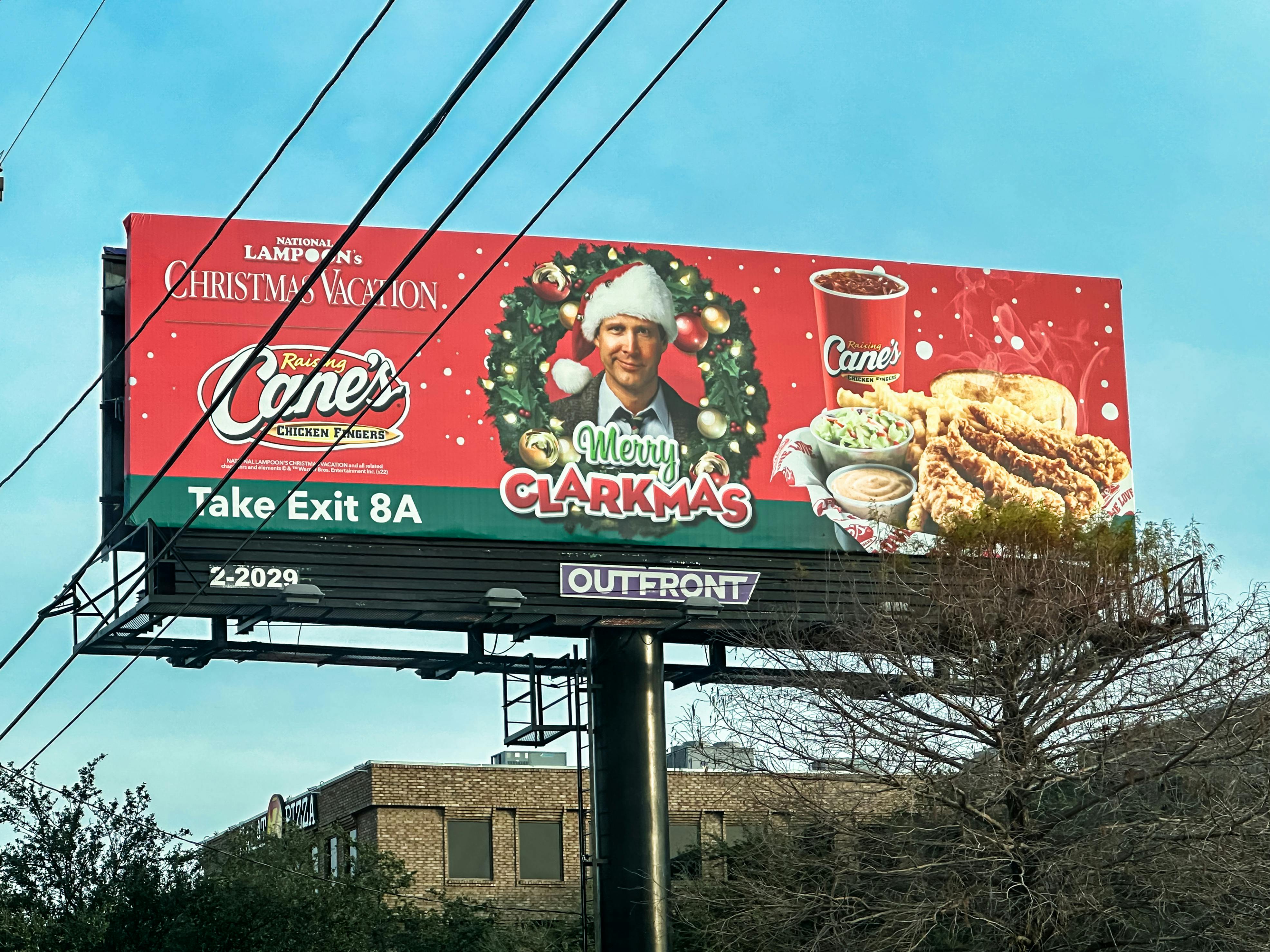Festive holiday billboard featuring promotional content for a popular chicken restaurant.