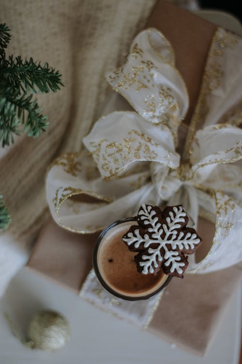 Coffee and a Gingerbread Cookie on the Background of Christmas Decorations 
